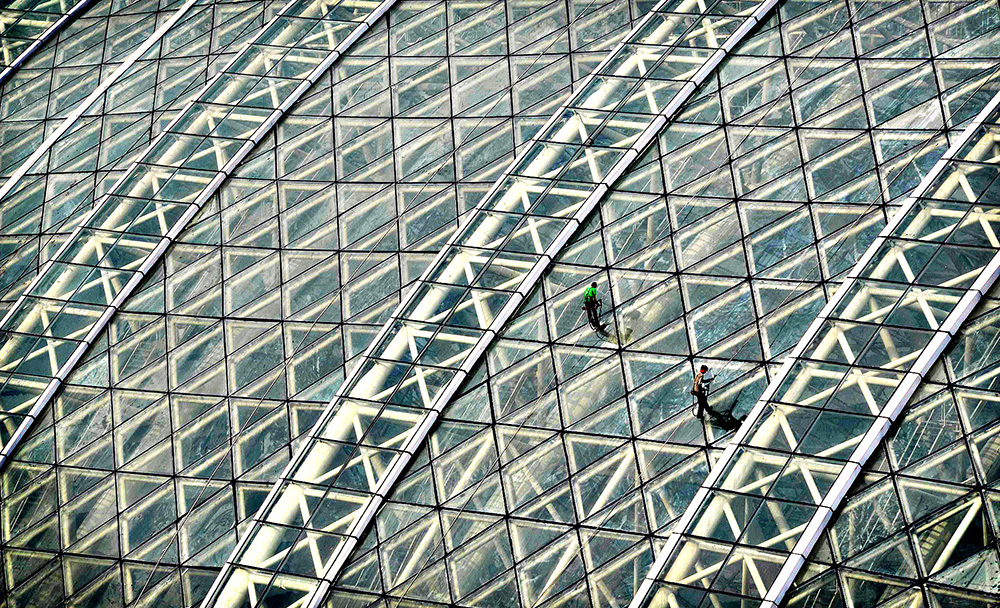 Workers clean the glass roof of the "New...Workers clean the gla