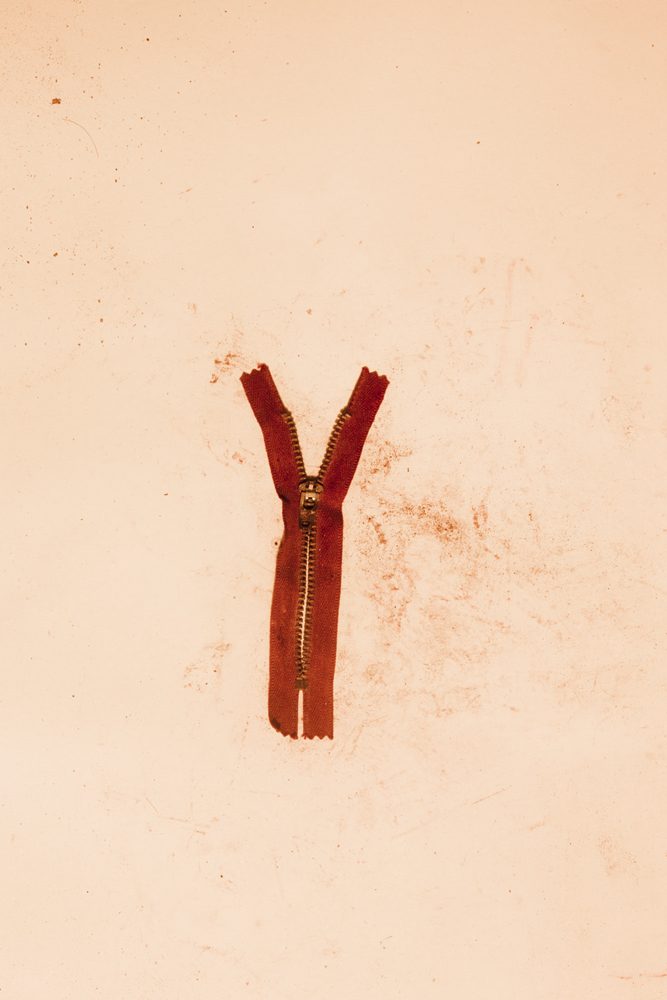 A zipper with reddish dirt found in the debris at Rana Plaza